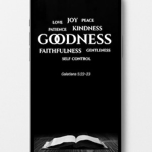 Può includere: Lo schermo di uno smartphone mostra un'immagine in bianco e nero con le parole "LOVE, JOY, PEACE, PATIENCE, KINDNESS, GOODNESS, FAITHFULNESS, GENTLENESS, SELF CONTROL" e "Galati 5:22-23". Un libro aperto in basso.