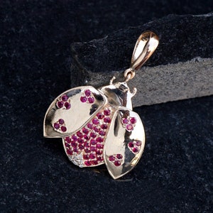 May include: Gold-tone pendant necklace featuring a ladybug design with red and clear rhinestones.