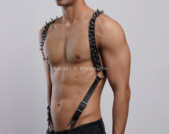 May include: Black leather harness with silver spikes, worn on a person's torso. The harness has adjustable straps and a ring at the top.