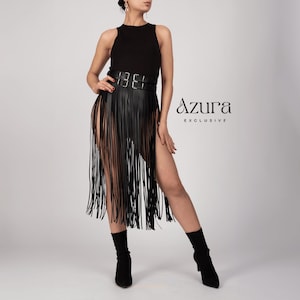 May include: Black fringe skirt with a high waist belt. The skirt has long, vertical fringe and high slits on both sides. The text "Azura Exclusive" is visible on the right side of the image.