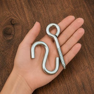May include: A silver-coloured metal S-hook and a silver-coloured metal eye bolt with a threaded screw end. Both hardware pieces have a smooth, polished finish and are designed for hanging or securing items in various construction or home projects.