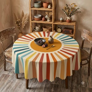 May include: A round tablecloth featuring a central mustard yellow circle surrounded by radiating stripes in shades of teal, yellow, orange, and red. The fabric has a scalloped edge and is draped over a circular table with two wooden chairs.