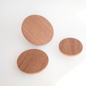 Op de afbeelding: Drie ronde houten wandhaken in verschillende maten. De haken zijn gemaakt van natuurlijk hout met een lichtbruine afwerking.