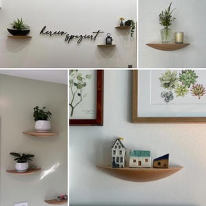 May include: A collection of wooden floating shelves, each holding decorative items like plants, miniature houses, and framed artwork. The shelves are mounted on a white and green wall, creating a minimalist aesthetic.