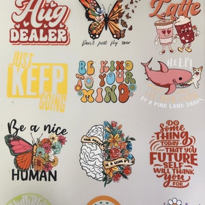 Puede incluir: Una colecci&oacute;n de pegatinas coloridas con varios dise&ntilde;os y texto. Los dise&ntilde;os incluyen mariposas, tazas de caf&eacute;, un tibur&oacute;n y frases como "Hug Dealer", "Be Kind to Your Mind" y "Do Something Today."