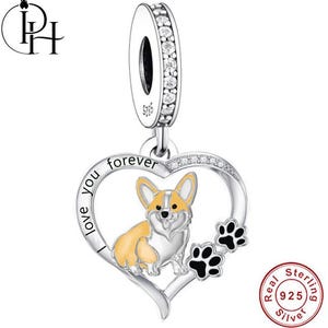 Könnte beinhalten: Ein Sterling Silber Charm mit einem Corgi-Hund-Design in einem herzförmigen Rahmen. Der Charm enthält die Worte "I love you forever" und zwei Pfotenabdrücke. Er ist mit klaren Kristallen verziert und mit "Real Sterling Silver" gestempelt.