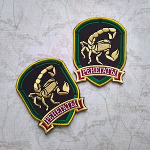 May include: Two black and green embroidered patches with a gold scorpion design and the word "Renegaty" in a red banner.
