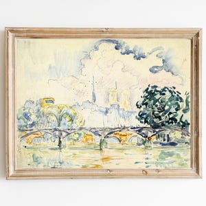 Könnte beinhalten: Ein Aquarellbild einer Brücke über einen Fluss mit einer Stadtlandschaft im Hintergrund. Das Bild ist in einem hellen Holzrahmen gerahmt.