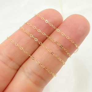May include: Delicate gold-colored chain with an oval link design. The chain is shown against a light background. This fine chain is suitable for jewelry making, such as necklaces and bracelets.