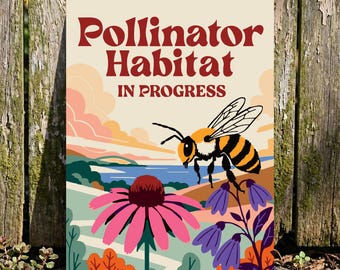 May include: A metal sign with the words "Pollinator Habitat IN PROGRESS" in burgundy. The sign features a colourful illustration of a bee, flowers, and a landscape with a lake and sky.