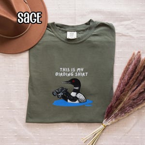 双眼鏡を持ったアビの刺繍入りバードウォッチングシャツ スウェットシャツ 野生動物の湖のシャツ 鳥好きの方へのギフト Sage