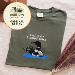 双眼鏡を持ったアビの刺繍入りバードウォッチングシャツ スウェットシャツ 野生動物の湖のシャツ 鳥好きの方へのギフト 画像 1