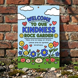 May include: A colorful metal sign with the text "WELCOME TO OUR KINDNESS ROCK GARDEN" in blue and green. The sign features cartoon flowers, hearts, and smiley faces against a light blue sky background. The sign is displayed outdoors.