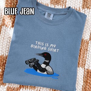 双眼鏡を持ったアビの刺繍入りバードウォッチングシャツ スウェットシャツ 野生動物の湖のシャツ 鳥好きの方へのギフト Blue Jean