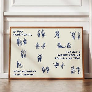 May include: A framed art print with a cream-colored background and a brown wooden frame. The print features blue line drawings of people and text that reads "IF YOU LOOK FOR IT," "LOVE ACTUALLY IS ALL AROUND," and "I'VE GOT A SNEAKY FEELING YOU'LL FIND THAT."