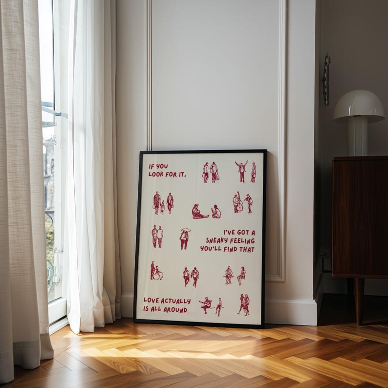 Puede incluir: L&aacute;mina art&iacute;stica enmarcada con borde negro. La impresi&oacute;n presenta ilustraciones rojas de personas y el texto "IF YOU LOOK FOR IT", "I'VE GOT A SNEAKY FEELING YOU'LL FIND THAT" y "LOVE ACTUALLY IS ALL AROUND."