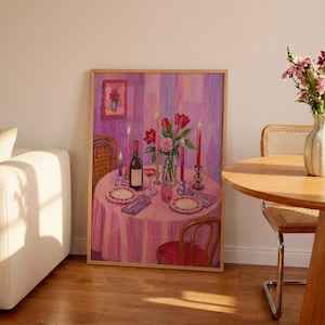 May include: A framed painting of a romantic dinner setting. A round table is set with plates, glasses, and a wine bottle, lit by candles and a vase of flowers. The colour scheme is dominated by pinks and purples.