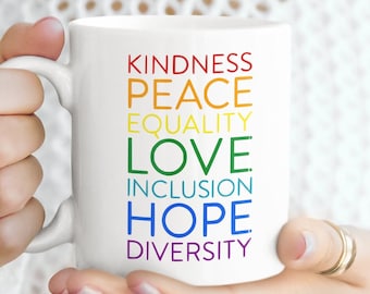 May include: White ceramic mug with a rainbow design featuring the words "Kindness, Peace, Equality, Love, Inclusion, Hope, Diversity".