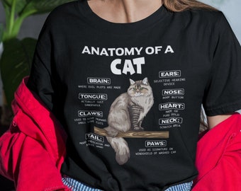May include: A black t-shirt with a white graphic of a cat and the text "Anatomy of a Cat". The graphic includes a humorous description of the cat's body parts, such as "Brain: Where evil plots are made" and "Tail: Mood indicator and magic wand".