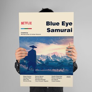 May include: A poster for the Netflix series "Blue Eye Samurai" featuring a stylized image of a samurai walking through a snowy village with a mountain in the background. The poster includes the title of the series, the creators' names, the cast, and the year 2023.