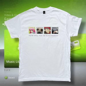 May include: White t-shirt with a crew neck. The shirt features four small square images: an anime character, a dog, a monkey, and a cartoon character. Below the images is the text "HOW WILL YOU BE REMEMBERED?"