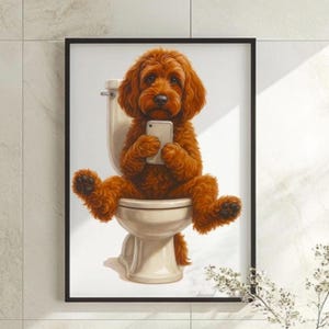 May include: Framed art print depicting a brown dog with curly fur, seated on a toilet and using a smartphone. The artwork is set in a bathroom and framed with a black border, suitable for home decor.