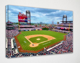 May include: An aerial view of a baseball stadium with a green field and a packed crowd. The scoreboard displays "Phillies" and "Realmuto".