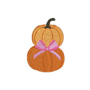 May include: Two orange pumpkins stacked on top of each other with a pink ribbon around the middle.