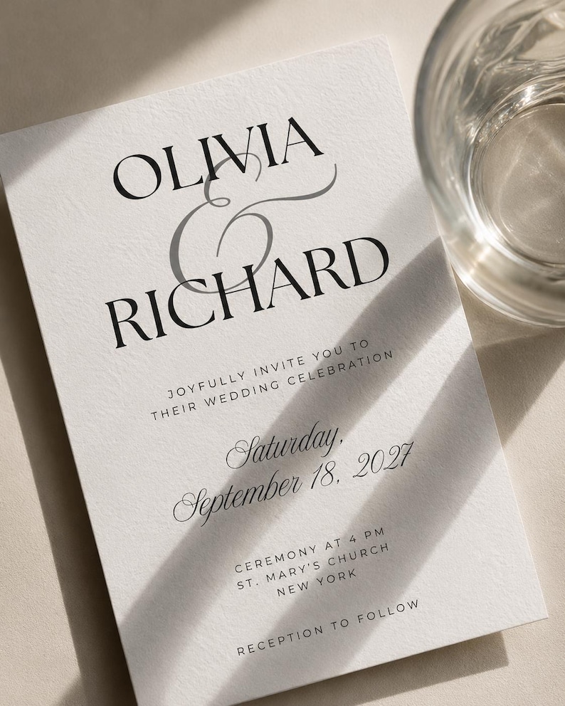 May include: A white wedding invitation card with black serif and script typography. The text reads: OLIVIA & RICHARD, JOYFULLY INVITE YOU TO THEIR WEDDING CELEBRATION, Saturday, September 18, 2027, CEREMONY AT 4 PM, ST. MARY'S CHURCH, NEW YORK, RECEPTION TO FOLLOW.