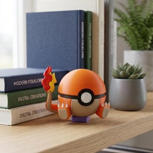 Puede incluir: Figura de Charmander naranja y marrón con cola de llama, sobre una base morada. Está en una estantería de madera con libros y una pequeña planta en maceta. Los libros tienen títulos como "Modern Folklore" y "Digital Creations."