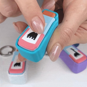 Puede incluir: Un conjunto de tres herramientas de perforación coloridas con diferentes formas de animales. Las herramientas están hechas de plástico y tienen una combinación de colores azul, morado y rosa. Cada herramienta tiene una forma de animal diferente en la parte superior, incluyendo una corona, una jirafa y un castillo.