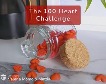 Puede incluir: Un tarro de cristal transparente con tapa de corcho, lleno de objetos en forma de corazón de color naranja. El tarro está volcado, derramando algunos corazones sobre una superficie blanca. El texto "The 100 Heart Challenge" se muestra en una pancarta roja.