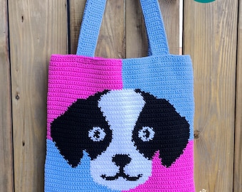 May include: A crocheted tote bag with a blue and pink background and a black and white dog face in the center. The bag has blue straps and the text "Y-Tee Creations" is visible in the bottom right corner. Crochet Pattern PDF.
