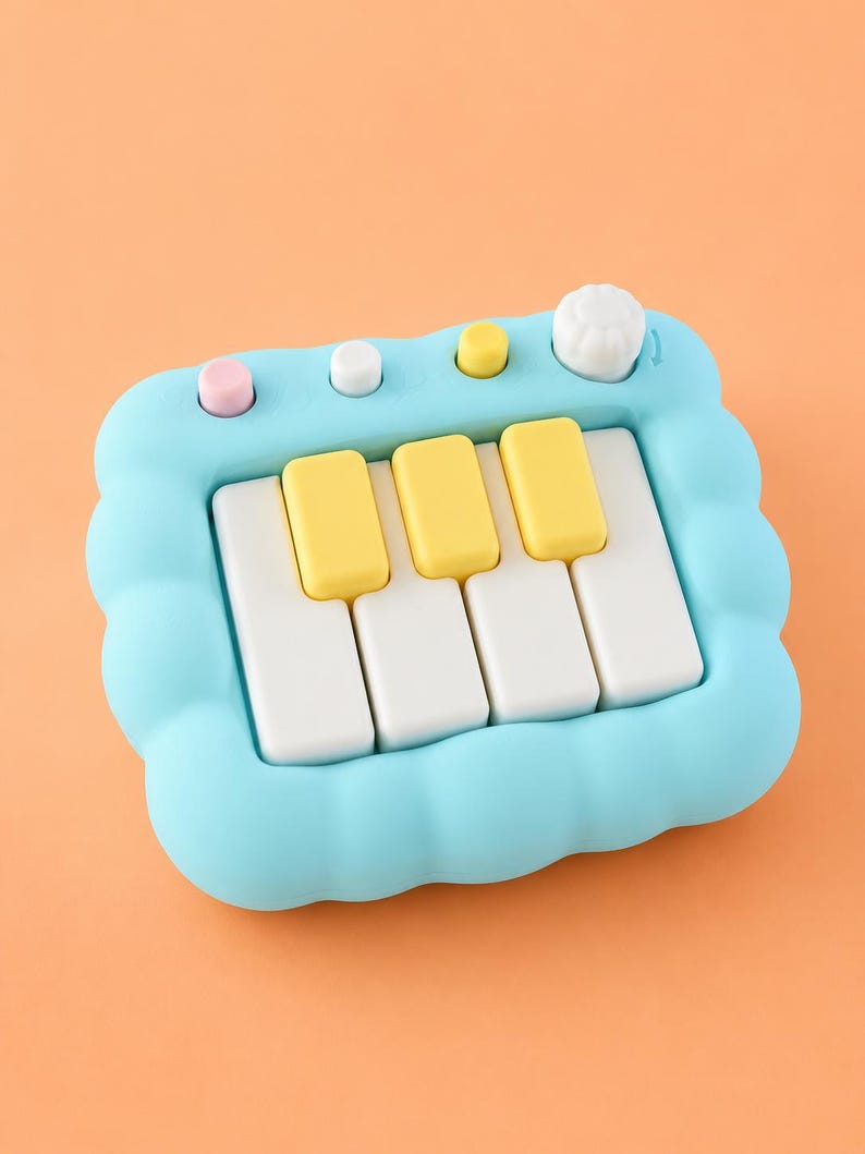 May include: A light blue toy piano with a cloud-shaped frame. The piano has white and yellow keys, and pink, white, and yellow buttons. A white knob is on the right side of the piano. The background is a solid orange color.