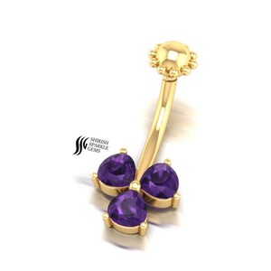 Può includere: Anello per ombelico in oro con tre pietre preziose viola a forma di cuore.