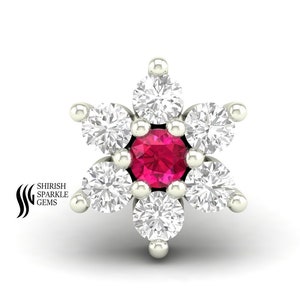 May include: A silver nose ring with a red gemstone in the center and six clear gemstones around it, forming a flower shape.