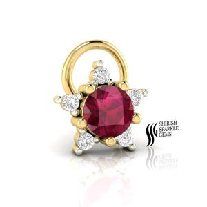 Puede incluir: Un aro de nariz de oro con una piedra preciosa de rubí rojo rodeada de piedras blancas más pequeñas en forma de estrella.