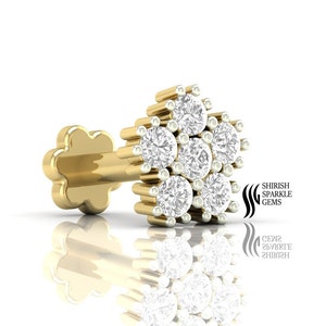 May include: Gold nose ring with a flower design and six small diamonds.