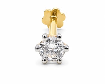 May include: A gold labret stud featuring a round, clear, faceted gemstone held in a six-prong silver-toned setting. The post is gold-colored and terminates in a flat, flower-shaped backing, providing a secure and decorative finish for this piece.