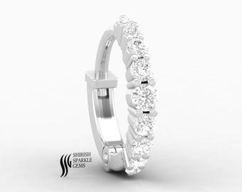 May include: A silver hoop earring with a row of round, clear gemstones. The earring has a hinged closure and is set against a white background. The brand name "SHIRISH SPARKLE GEMS" is printed on the lower left.