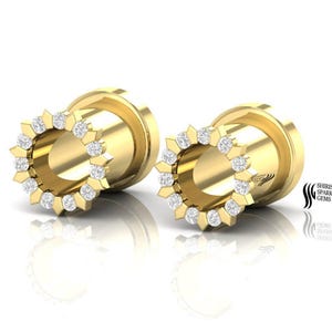 May include: A pair of gold ear gauges with a diamond-encrusted border. The gauges are circular and have a smooth, polished finish.