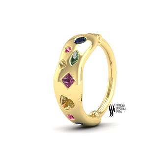 May include: A gold ring with a series of colorful gemstones in various shapes, including round, oval, and heart-shaped. The ring has a smooth, polished finish and a curved design. The gemstones are in shades of blue, pink, green, yellow, and purple.