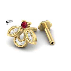 May include: A gold stud earring shaped like a bee, featuring a small round red gemstone for the head and clear white stones embedded in the wings and body. The earring includes a threaded post and a flower-shaped backing. Text reads Shreesh Sparkle Gems.