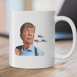 May include: White ceramic mug with a cartoon image of a man with a surprised expression. The text "My... My... My..." is printed on the mug.