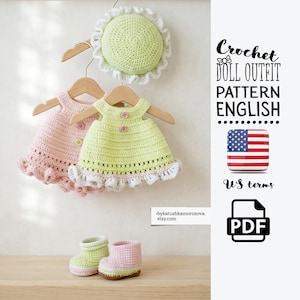 May include: A crochet doll outfit pattern in English with US terms, featuring a light green hat with a white ruffled edge, a pink dress, a light green dress with two pink buttons, and a pair of matching light green and pink crochet booties.