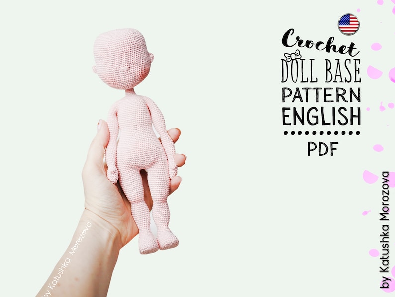 May include: A pink crocheted doll base pattern in English, available as a PDF download. The pattern is for a doll with a simple, rounded head and limbs. The doll is held in a hand, with the American flag visible in the upper right corner of the image.