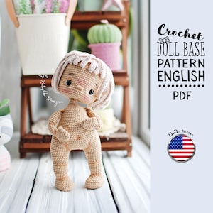 May include: Crochet doll base pattern in English, written in US terms. The pattern is for a nude doll with pink hair, standing on a wooden surface. The pattern is available as a PDF download.