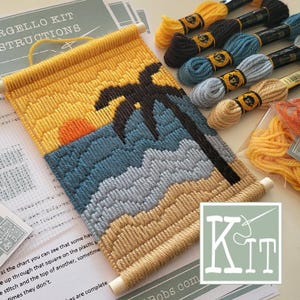 Pode incluir: Um kit de bordado Bargello com uma cena de praia ao pôr do sol, uma silhueta de palmeira preta, ondas azuis e areia amarela. O kit inclui uma haste de madeira para pendurar, várias meadas de linha de bordar coloridas e instruções impressas.