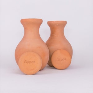 Peut inclure: Deux vases en céramique de couleur terre cuite avec des couvercles. Les couvercles portent le mot "Alppas" en relief.