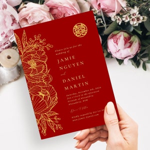 Op de afbeelding: Rode huwelijksuitnodiging met een gouden bloemmotief en de tekst "U bent van harte welkom op de bruiloft van Jamie Nguyen en Daniel Martin. Zaterdag 4 november 2024, vijf uur 's middags, Grounds of Alexandria, Alexandria, NSW. Dansen en diner. Graag uw antwoord v&oacute;&oacute;r 1 oktober 2024. www.Jamie-Daniel.com"